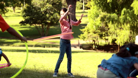 amigos pequeños jugando con hula hoops en el parque