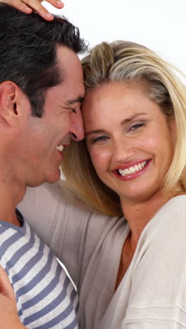 happy young couple embracing each other against white background