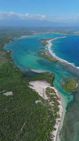turquoise and blue shallow waters, playa caobita, dominican republic. aerial sideways, vertical format, copy space