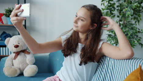 teenage girl taking a selfie on a couch