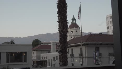 view of pasadena city hall from behind a tree across the way from a balcony