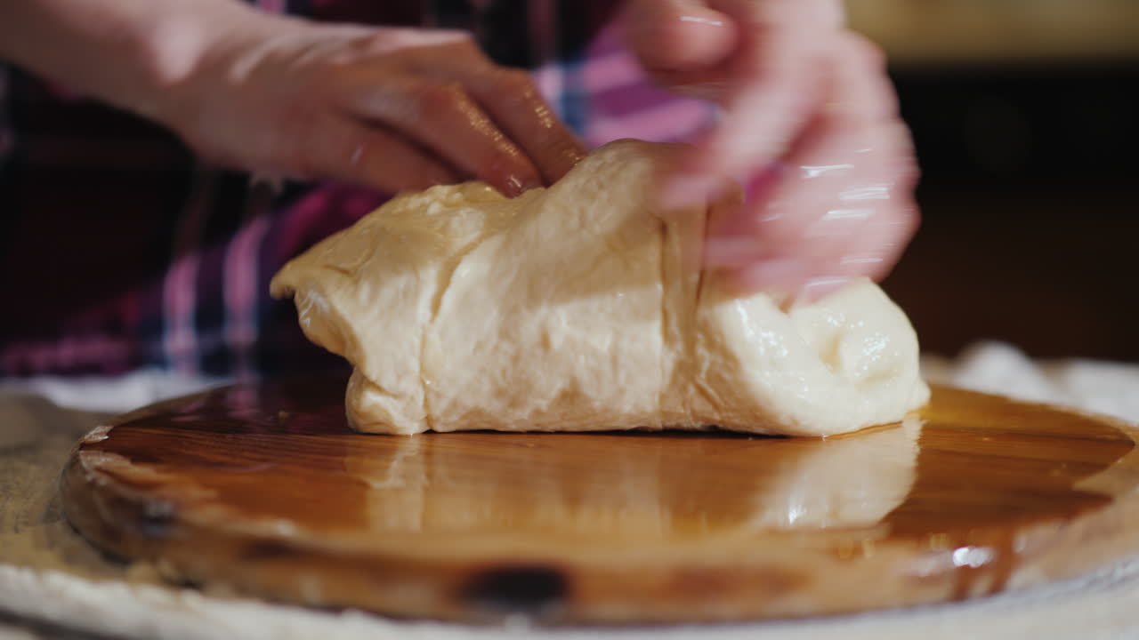 클로즈업 - 손으로 나무 판자에 반죽을 반죽하고 판자는 식물성 기름 4k 비디오로 기름을 바른다