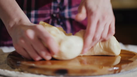 primer plano - las manos amasan la masa en una tabla de madera la tabla está engrasada con aceite vegetal 4k video