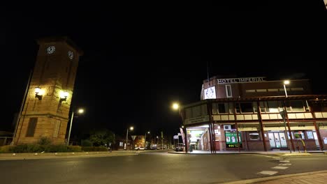 cars pass by a historic building at night