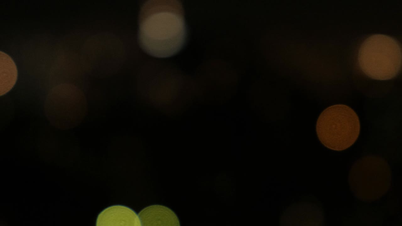 Blurred bokeh light spots on black background.