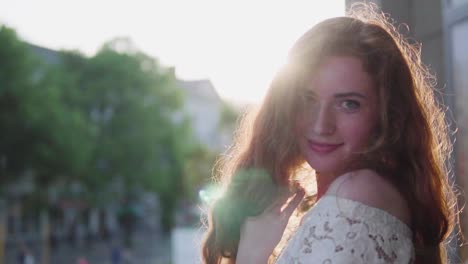 beautiful natural young girl with red curly hair going between the pillars in the park like angel-princess