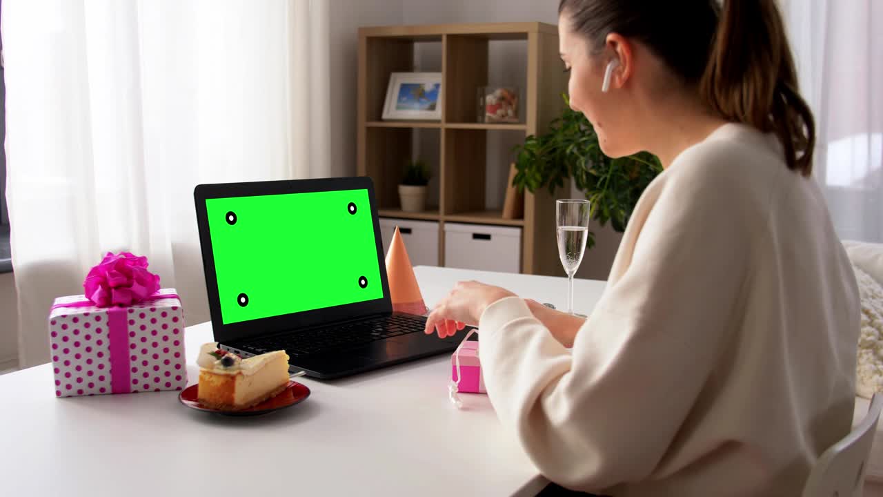 노트북을 가진 여성이 가상 생일파티를 열고 있습니다.