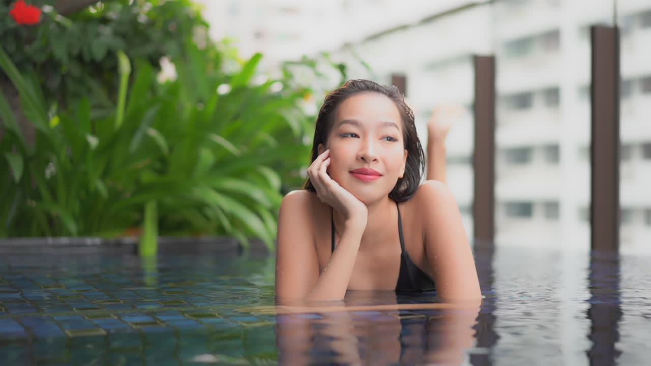 웰빙 호텔 수영장 슬로모에서 공상을 하는 아름다운 아시아 소녀