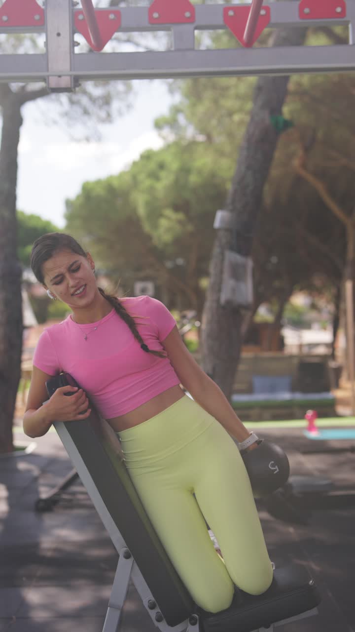 Woman Exercising with Dumbbell on Incline Bench Outdoors