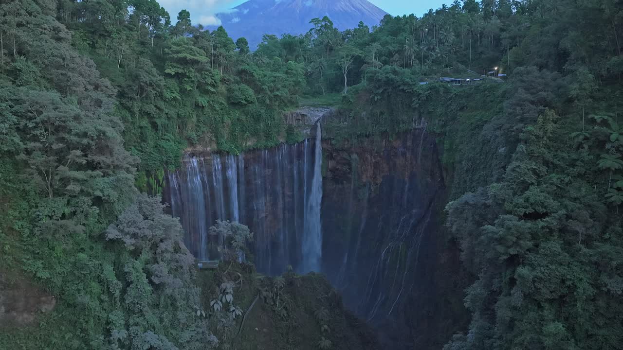 Arka planda Semeru Yanardağı ile bir kanyonda akan Tumpak Sewu Şelalesi.