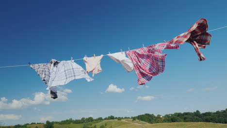 a woman with a basket looks like hanging wet clothes on a rope 4k video