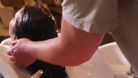 A-professional-hairdresser-rinsing-a-woman´s-hair