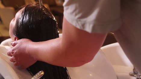 a professional hairdresser rinsing a woman´s hair