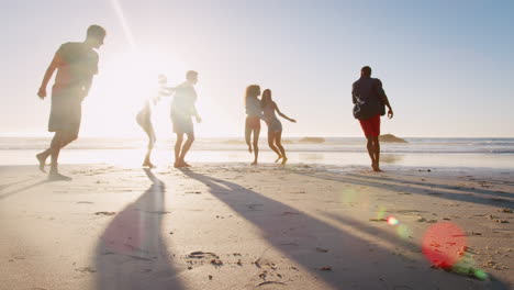 group of friends on shoreline having fun on beach vacation