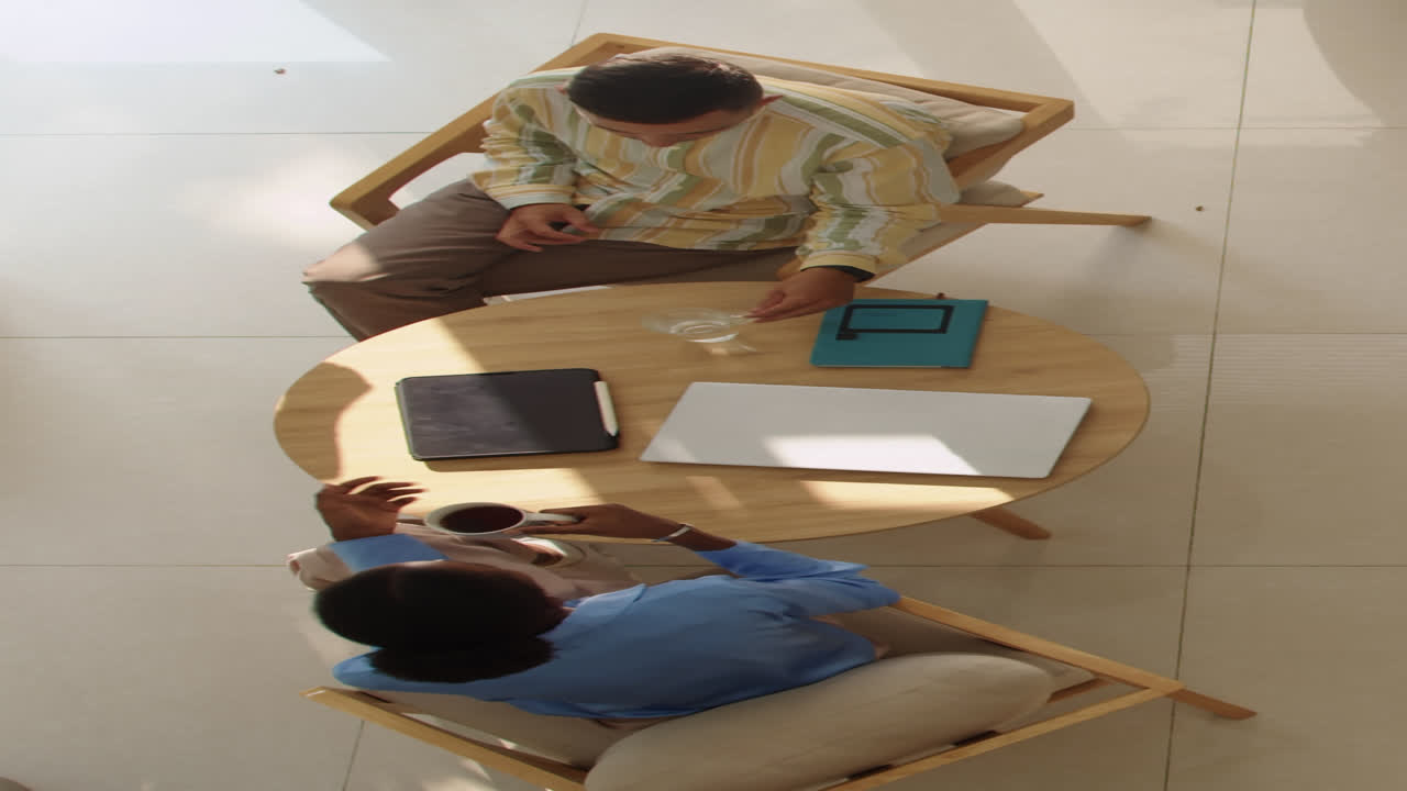 Vertical of Coworkers Chatting during Coffee Break Top View