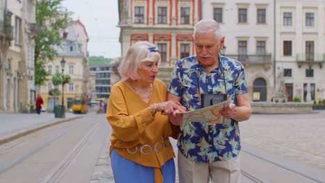 Senior-grandmother-and-grandfather-tourists-looking-for-a-place-to-go-in-new-city-using-paper-map