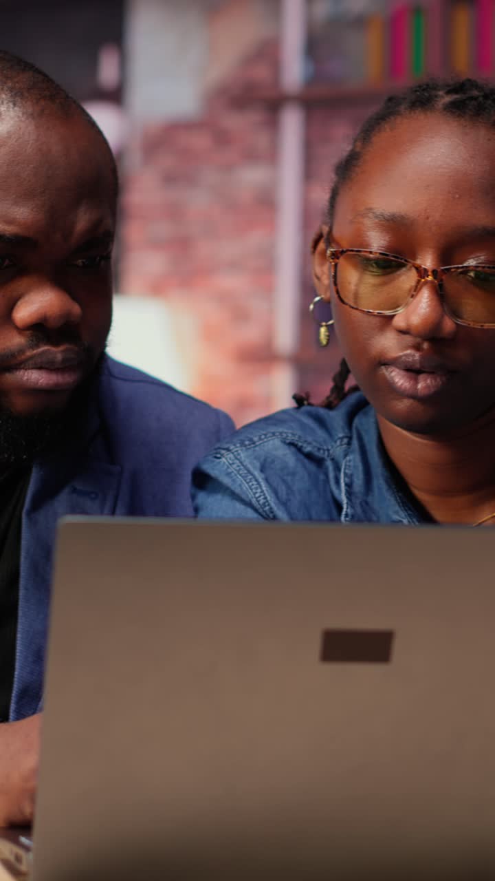 African American Colleagues Collaborating on Laptop in Office