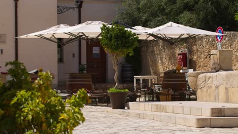 Sunny day in Scopello city center with outdoor seating in Italy