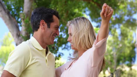pareja sonriente señalando en un día soleado