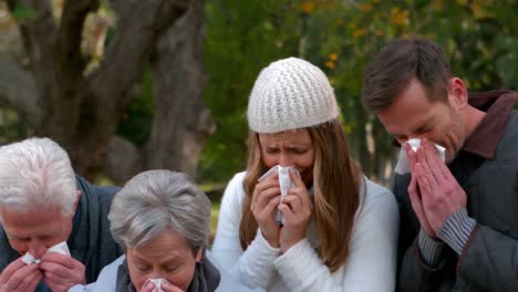 sick family sneezing into tissues