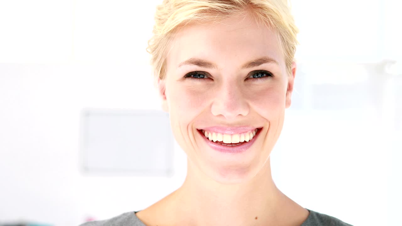 Pretty blonde woman looking at camera in office
