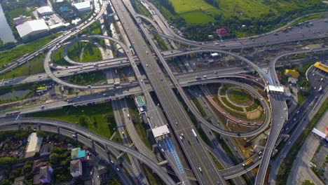 aerial view of highway road interchange with busy urban traffic speeding on road