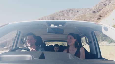 vista desde el exterior del vehículo como coche de conducción familiar a lo largo de la carretera de montaña al destino de vacaciones