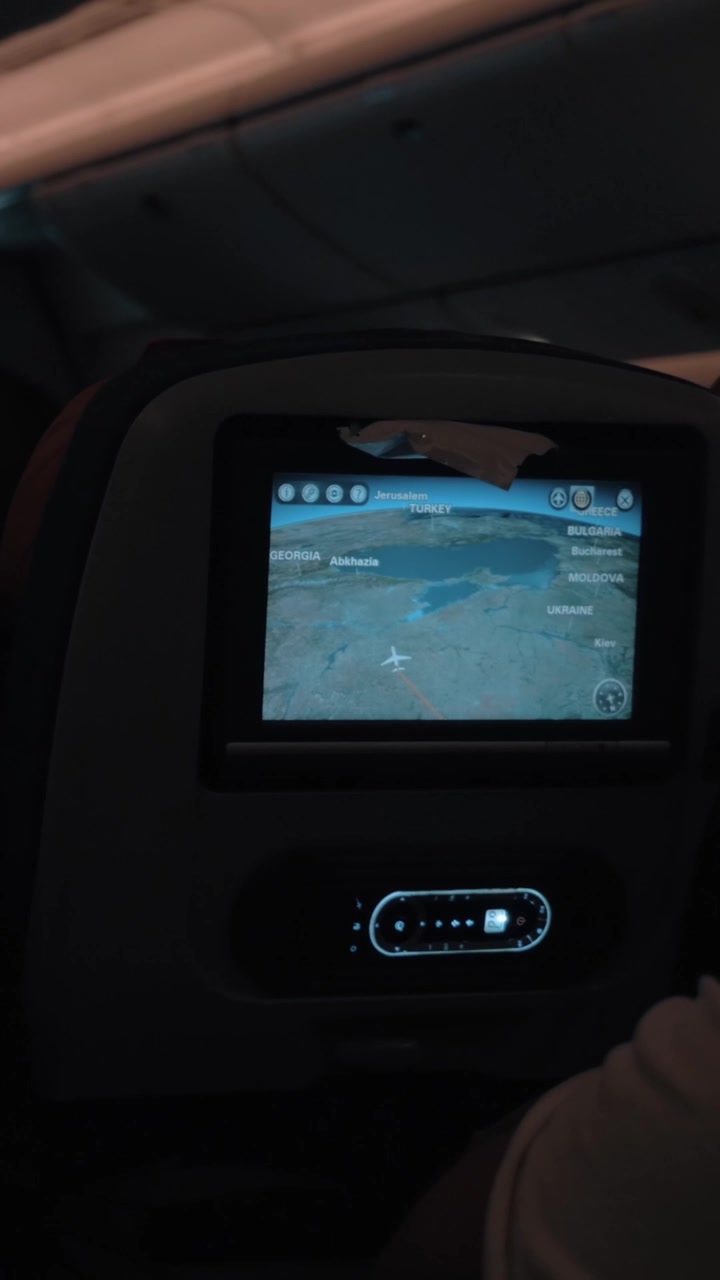 Passeggeri che viaggiano in aereo di notte. Cabina buia con monitor dei sedili funzionanti.