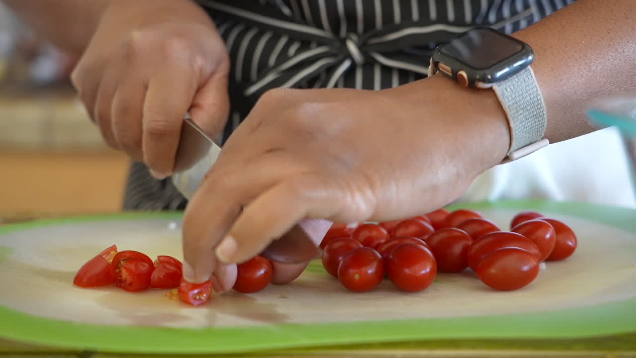 cortar tomates cherry por la mitad para hacer una ensalada picada - serie de ensalada antipasto