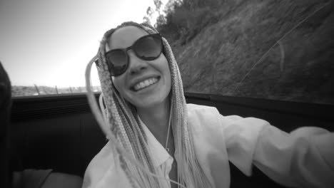 joyful woman with braids in a convertible car