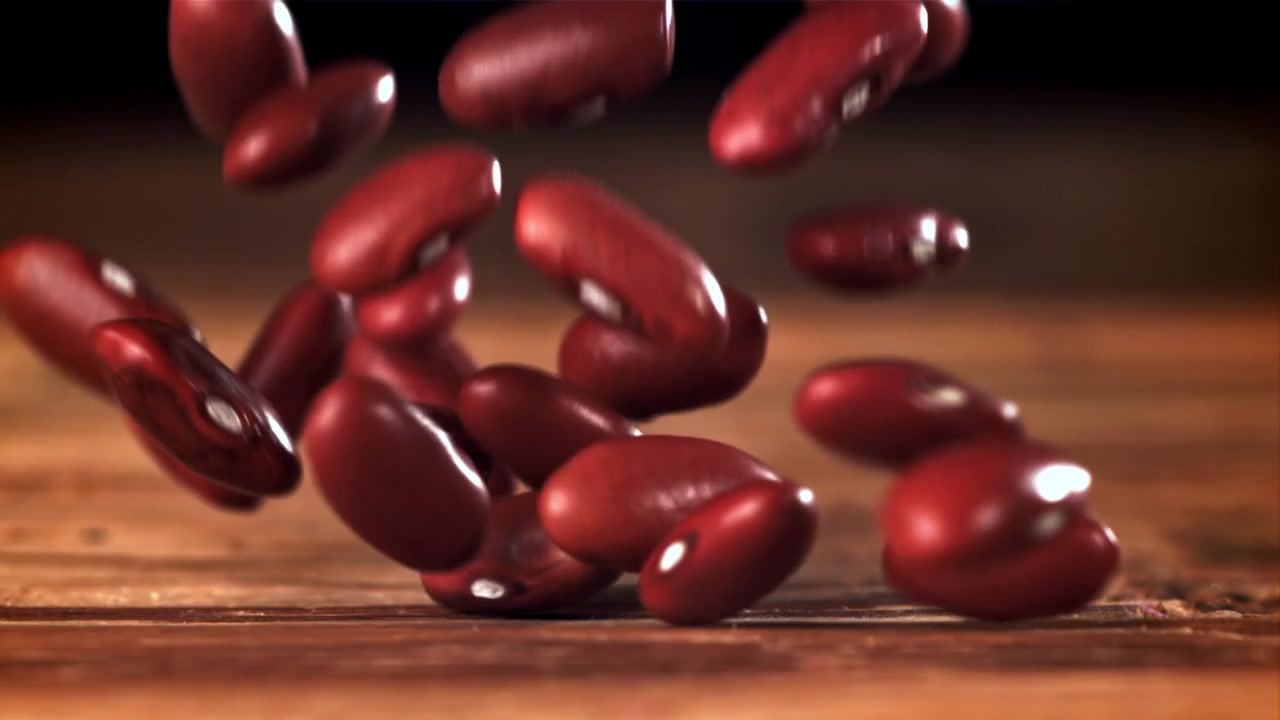 Red Kidney Beans Falling in Slow Motion on Wooden Surface