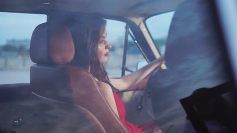 una mujer conduciendo un coche de época.