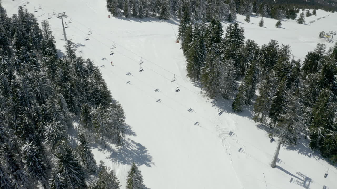 Vista aerea di una stazione sciistica innevata con impianti di risalita e pini
