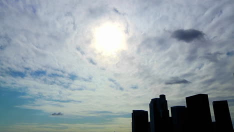 Lapso-De-Tiempo-De-Las-Nubes-Pasando-Sobre-Un-Horizonte-Urbano-En-Silueta