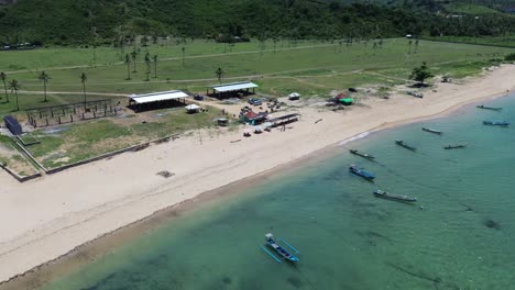 Hohe-Aussicht-Auf-Den-Strand-Von-Areguling-Mit-Fischerbooten,-Lokalen-Restaurants-Und-Touristen