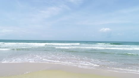 Aerial-dolly-forward-in-deserted-beach-landscape-on-a-sunny-day