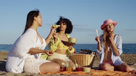 three women having a picnic on the beach