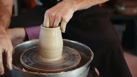 ceramist uses potter's wheel and creates a handmade clay product