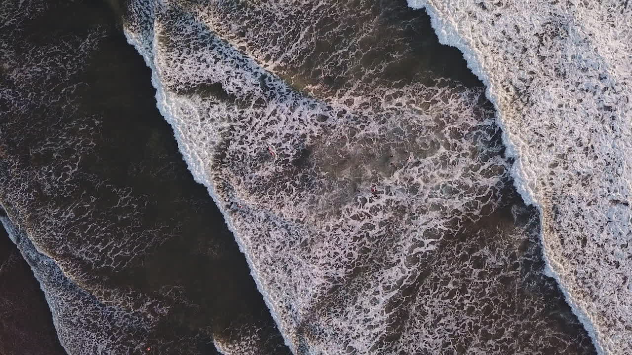 olas blancas rodando hacia la costa de la playa de olon en ecuador