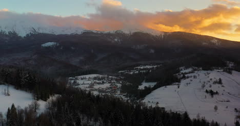 Aerial-View-Of-Mountains-And-Forest-Covered-With-Snow-At-Sunset-In-Winter-7