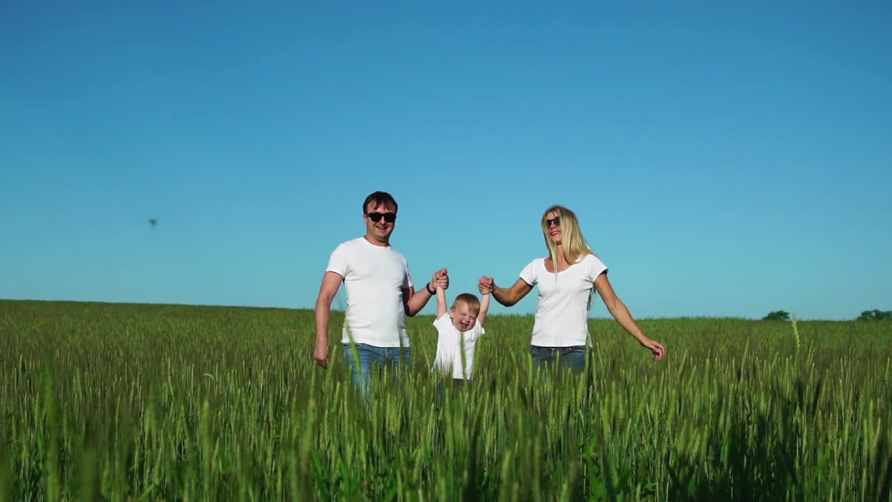 아버지와 아들은  ⁇  티셔츠와 청바지를 입고  ⁇ 니와 함께  ⁇ 에서 걸어가며 손에 흔들고 재미있습니다.