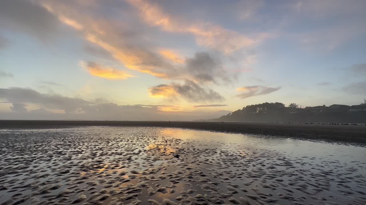 Reflections of the sunset in the wet sand of the Oregon coast beach