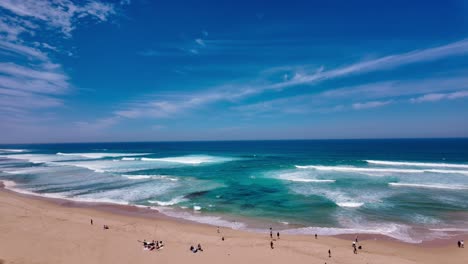 footage of gibson beach in melbourne australia along the famous great ocean road. a horizontal panning footage of the beach reveals the large number of tourists enjoying the ocean wind and waves.