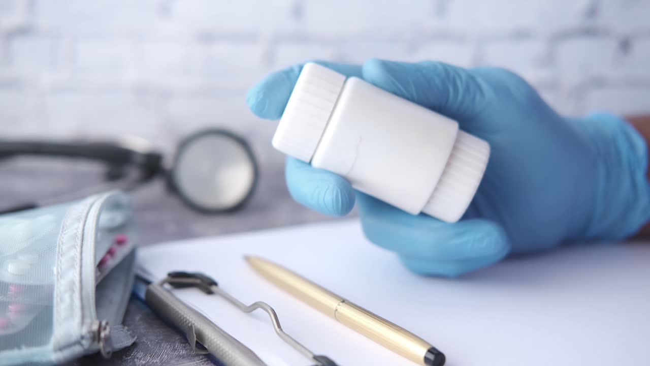 Medico che tiene un flacone di pillole