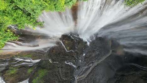 aerial spins straight down tumpak sewu waterfall cliff on java, idn