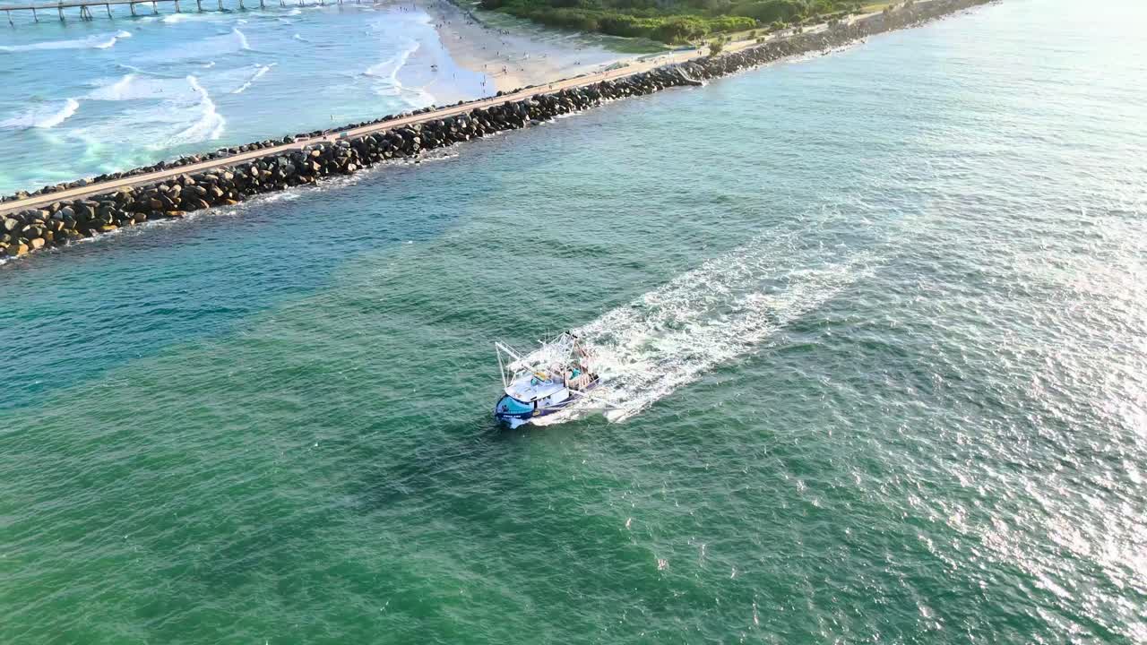 해가 지면 트롤러가 바다를 빠르게 이동합니다.