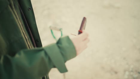 코트 주머니에서 호기심 많은 오래된 노트북을 꺼내는 남자의 클로즈업