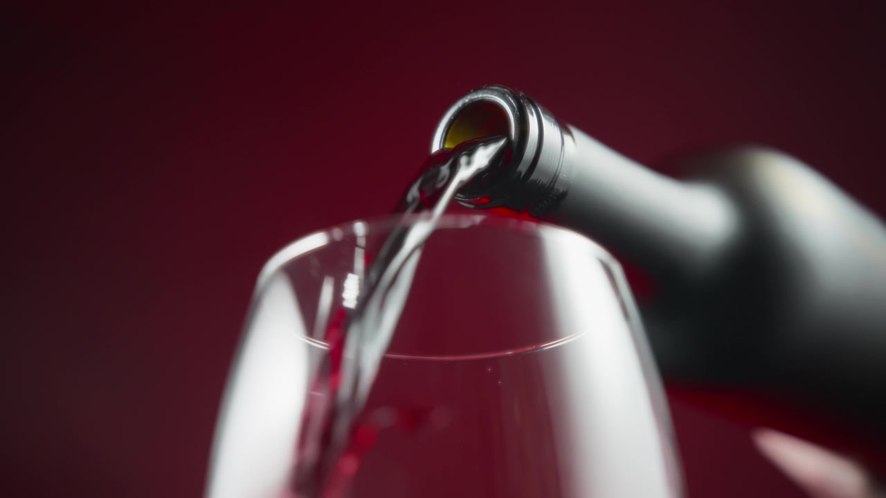 Vino rosso versato dalla bottiglia.