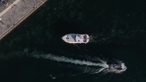 Touristic-Boat-Sailing-By-The-Coast-Of-Amalfi-City,-Mediterranean-Sea,-Italy---aerial-top-down