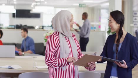 group of diverse business people holding documents and talking in office, slow motion